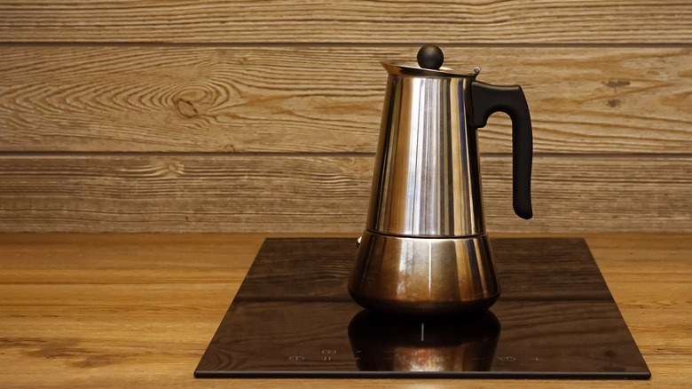 Metal coffee percolator on an electric stove