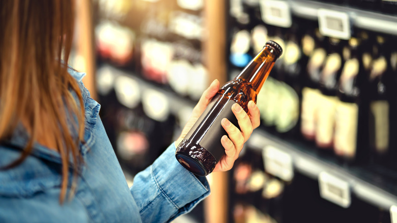 Woman looking at beer bottle
