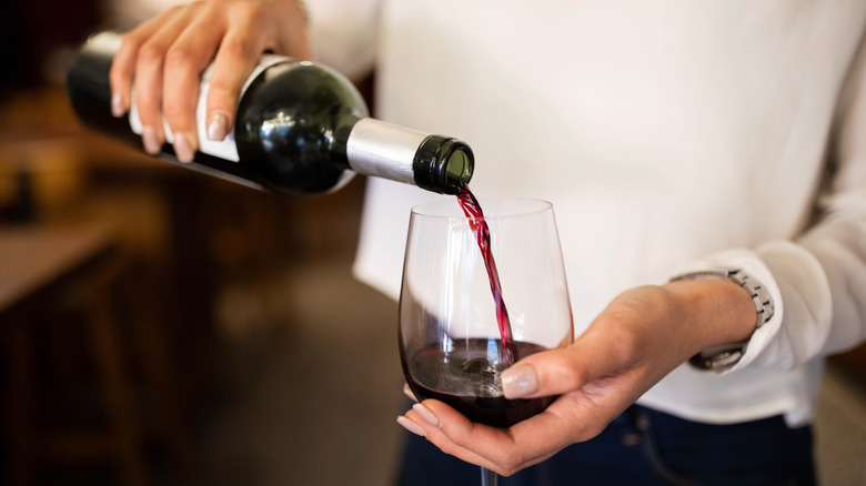 Woman pouring glass of red wine