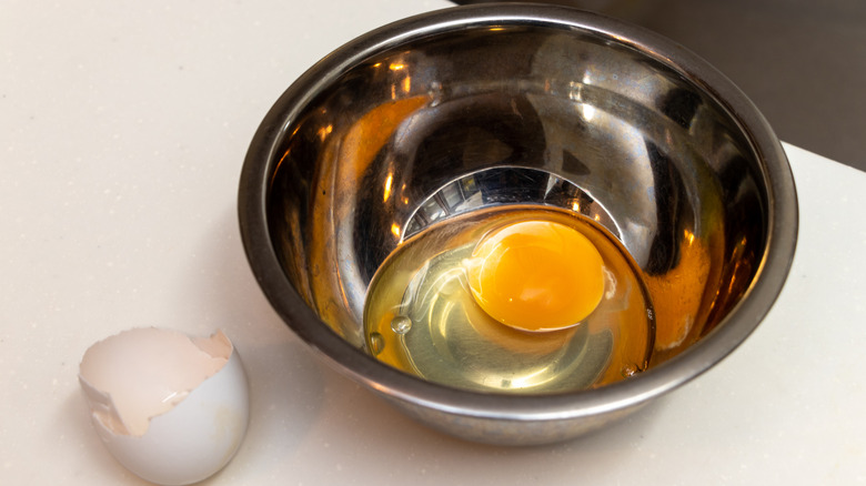cracked egg in silver bowl