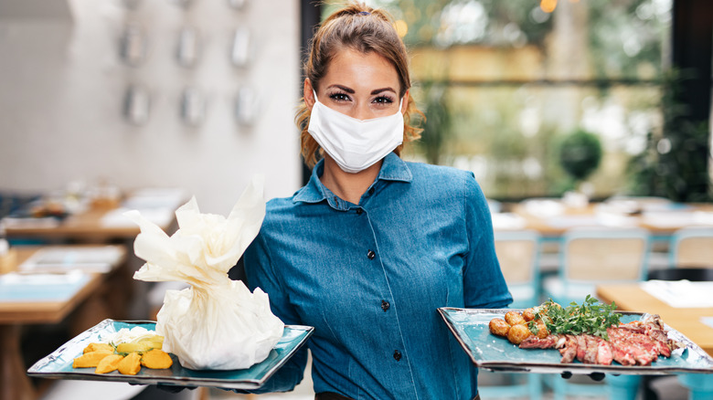 Server carrying trays of food