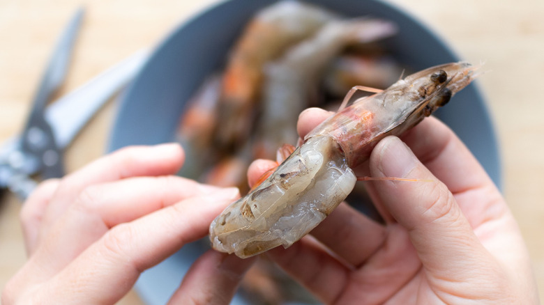 person deveining shrimp for cooking