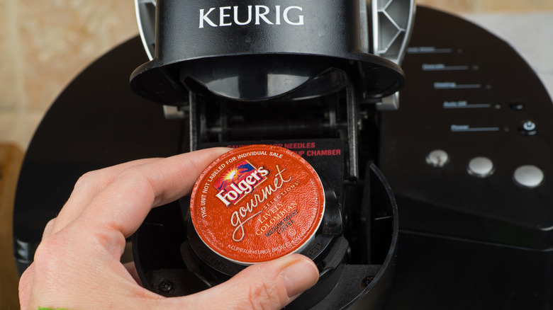 Inserting a K-Cup into a Keurig machine.