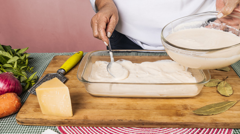 Adding sauce to lasagna dish