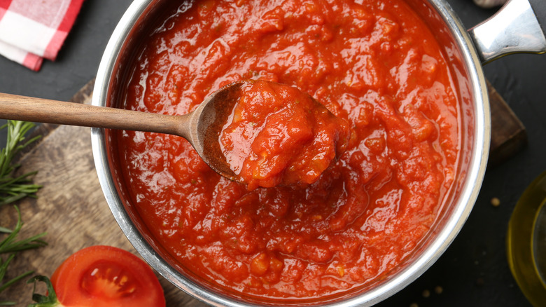 Pot of tomato sauce with a wooden spoon