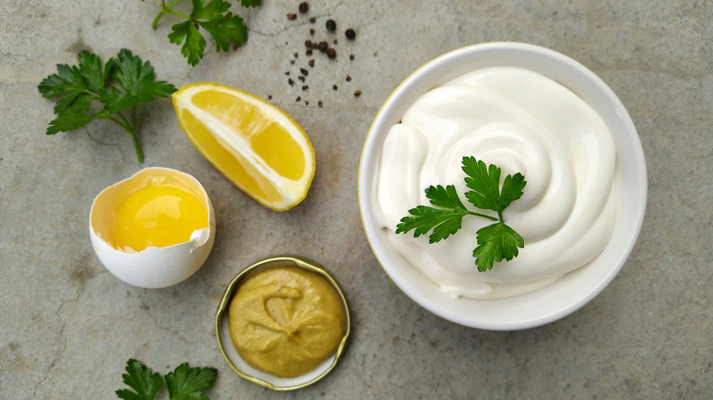 Bowl of mayo with egg, lemon, and mustard