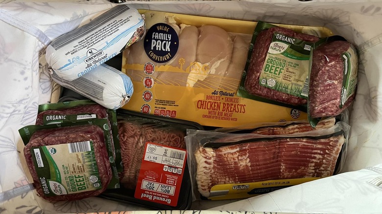 A shopping bag contains multiple packs of meat from Aldi