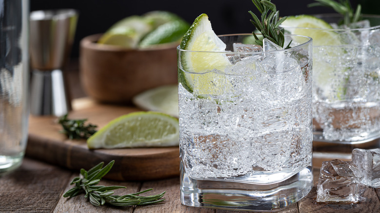 Carbonated cocktail in glass with lime