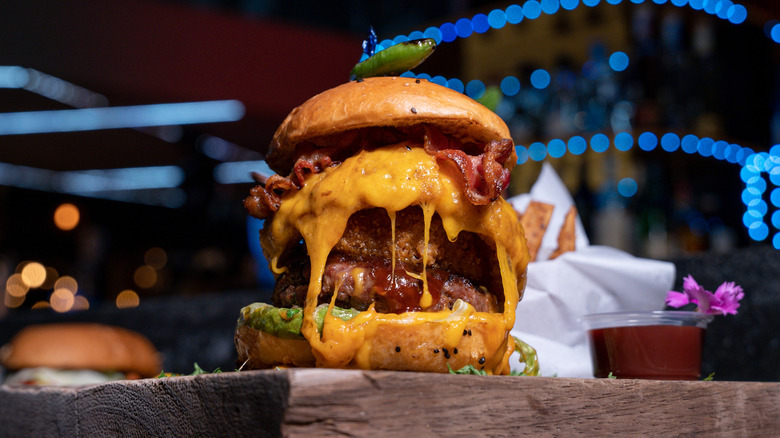 Double-beef patty cheeseburger on wooden board