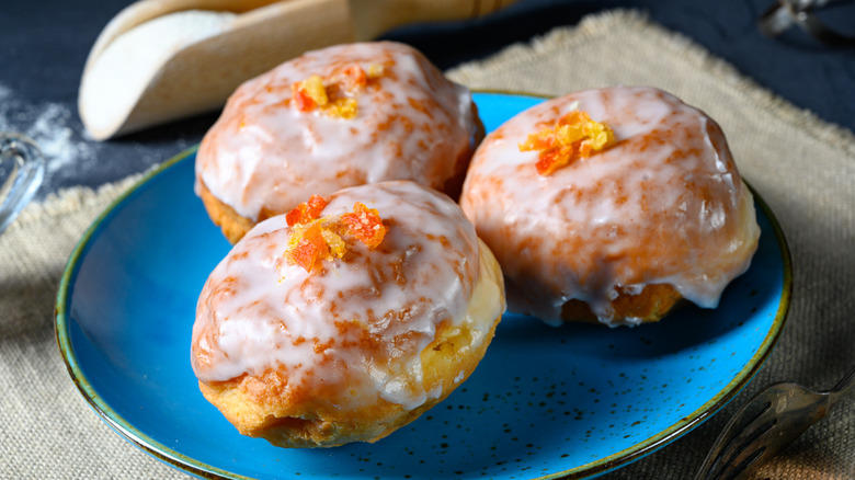 Paczki Polish glazed jelly donuts with candied orange peel on blue plate