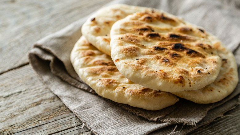 Two pieces of pita bread on brown napkin