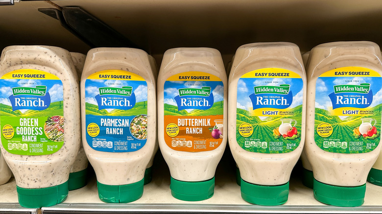 Bottles of ranch dressing sit on a supermarket shelf