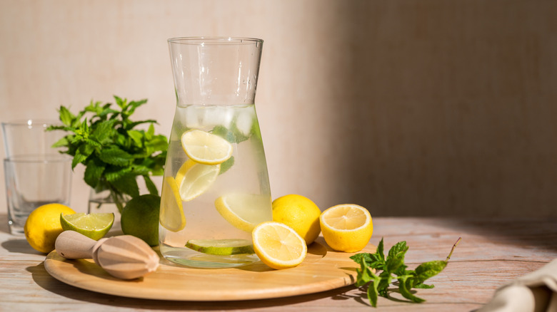 A jug of water containing fresh lemons.