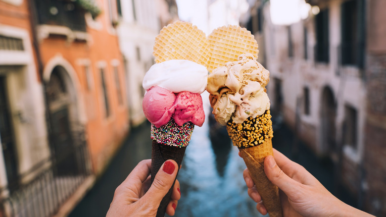 Hands holding gelato in Italy.