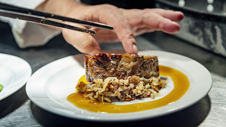 Chef plating steak medallions