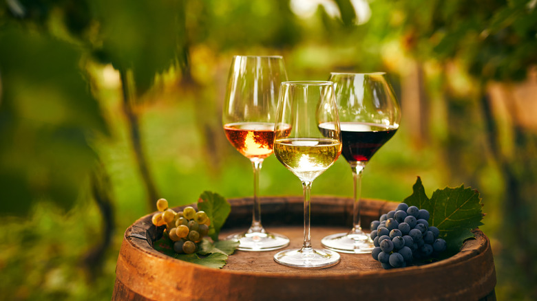 wine glasses on barrel with grapes