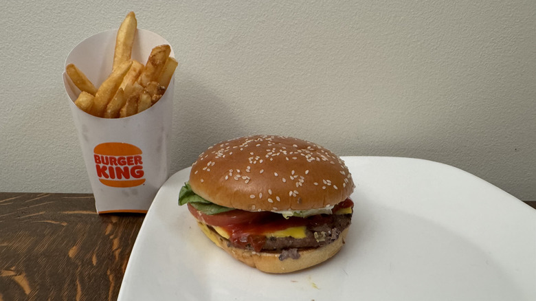 Whopper on plate next to Burger King soft drink