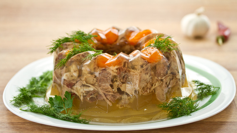 An aspic from a mold garnihed with fresh dill.