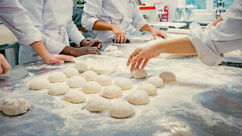 Bakers preparing bread in industrial setting