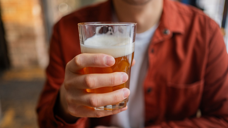 Person holding up beer.