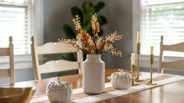 a dining room table with a fall centerpiece