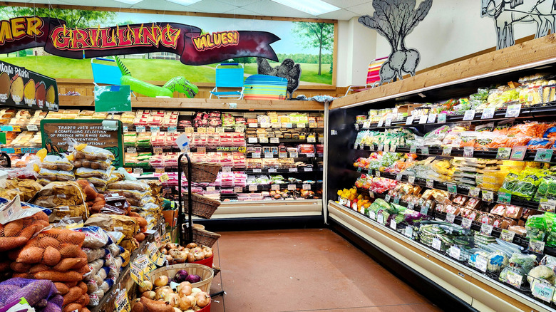 The produce and beef areas of a Trader Joe's store with summer grilling art on the wall