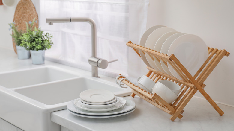 A full dish rack next to a sink