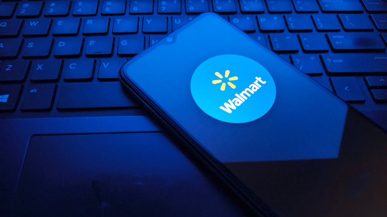 The Walmart app logo appears on a phone that sits on a keyboard