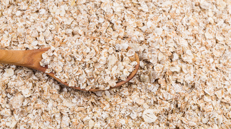 Wooden spoon in rolled oats