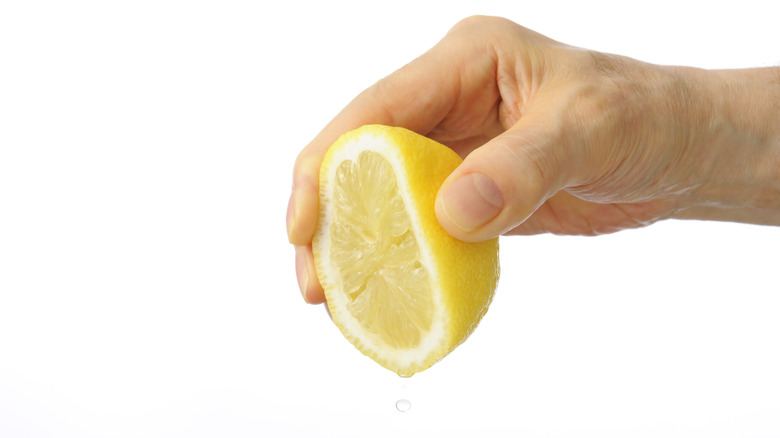 hand squeezing lemon