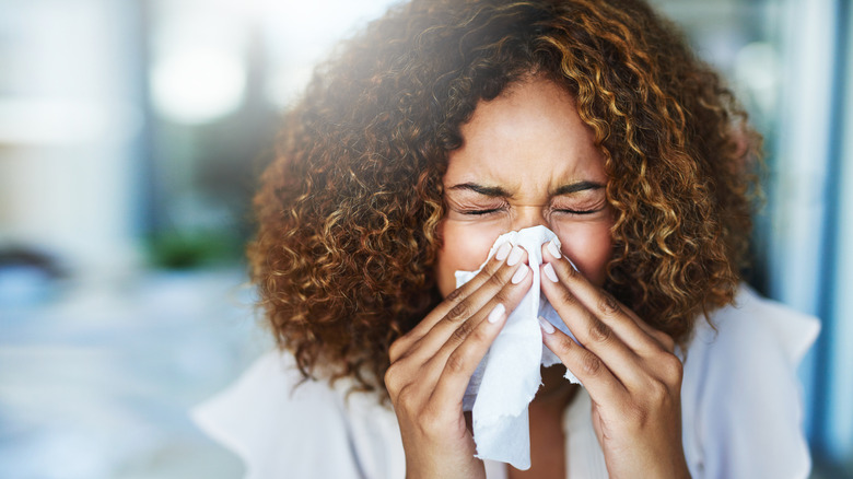 Person who is sick blowing their nose