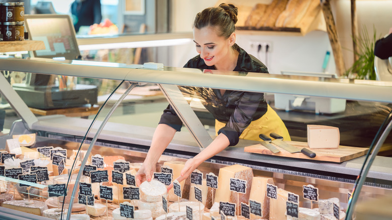 Cheesemonger organizing cheese display