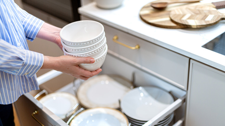 Person holding bowls in kitchen