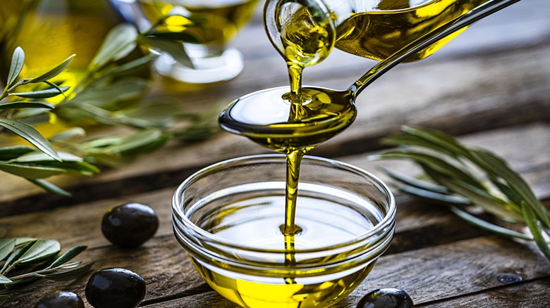 Olive oil poured into a bowl over a spoon