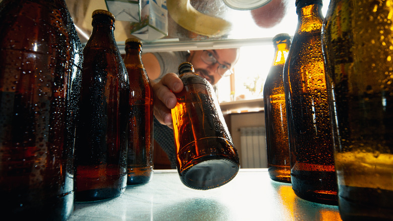 Man removing beer from fridge
