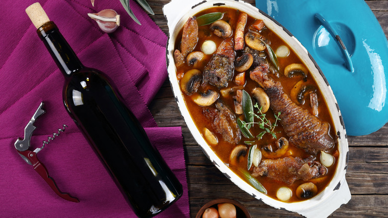 coq au vin with a bottle of red wine