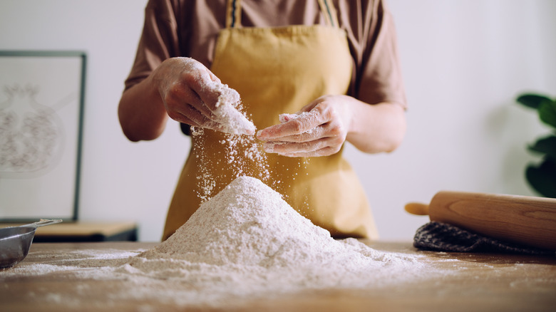 Person handling pile of flour