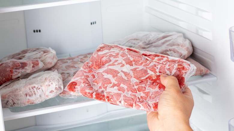 person removing frozen meat from the freezer