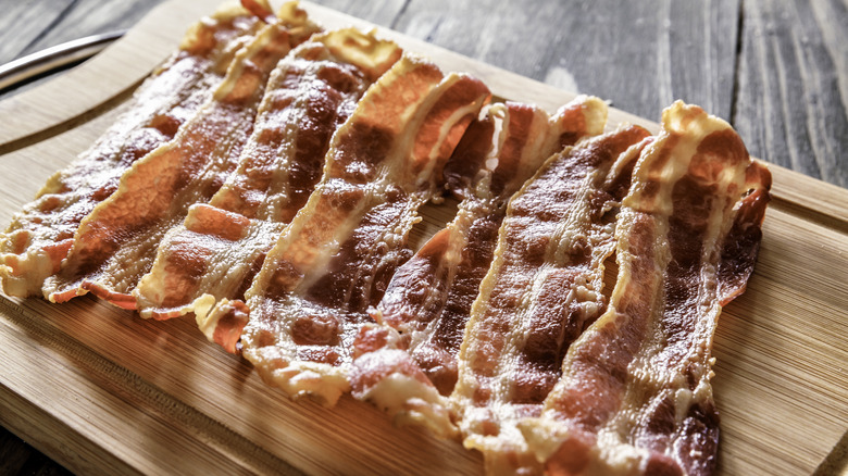 cooked bacon on cutting board