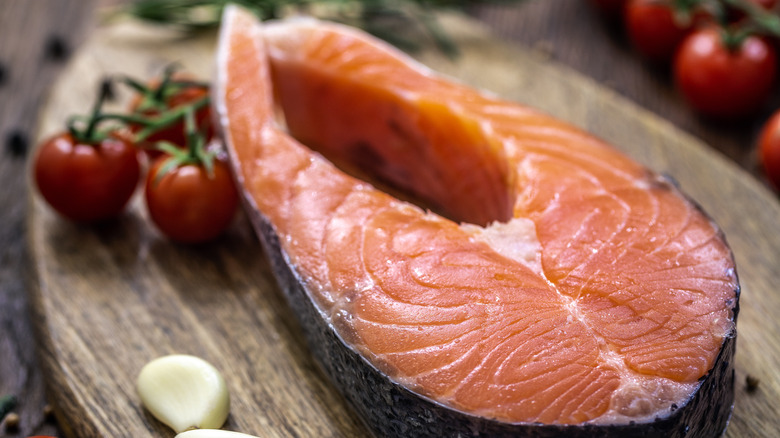 raw salmon steak with garlic and tomatoes