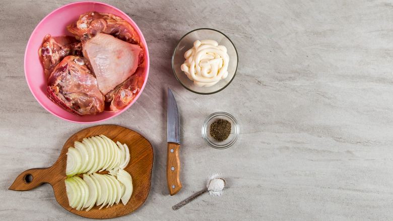 Raw chicken with mayonnaise marinade and onion