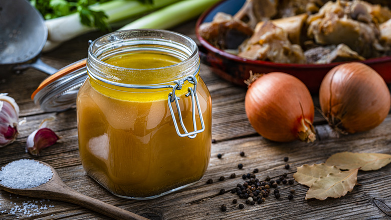 Broth in glass jar with onions, salt, pepper, bay leaves