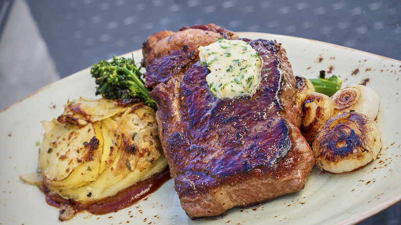 Seared ribeye steak with herby compound butter with turnips, broccoli rabe, and mash