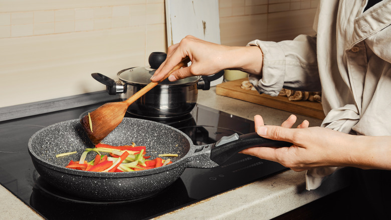 person cooking on a glass stovetop