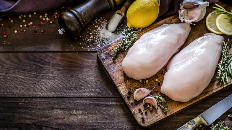 raw chicken breasts on cutting board