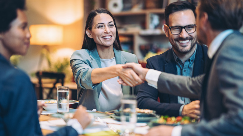 shaking hands at business dinner