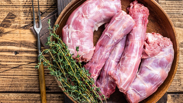 raw turkey meat pieces in wooden plate with thyme