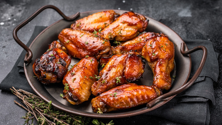 Chicken covered in barbecue sauce on a grill.