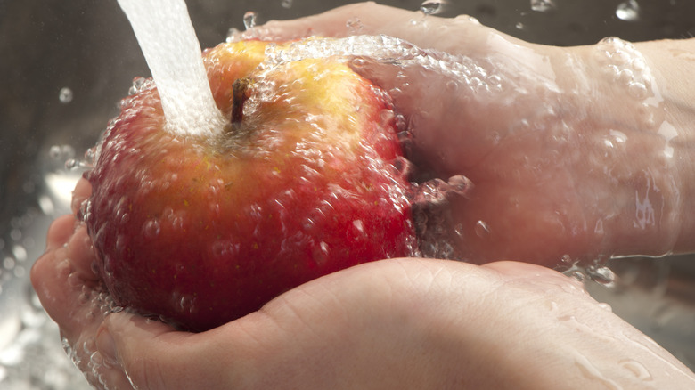 Washing an apple in the sink