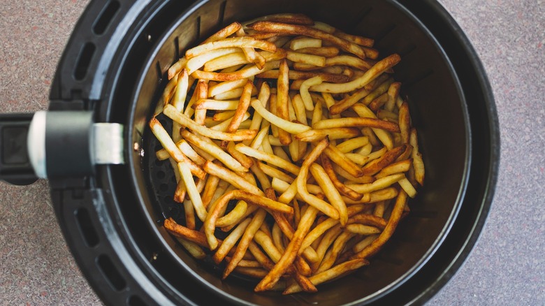 Crispy french fries inside air fryer basket